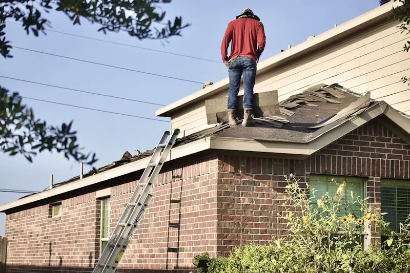 Professional roofer working on a residential roof in Divide